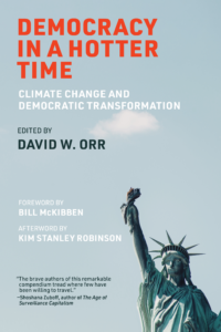 Cover of the book "Democracy in a Hotter Time: Climate Change and Democratic Transformation" edited by David W. Orr, featuring a photo of the Statue of Liberty against a blue sky with text contributions by Bill McKibben and Kim Stanley Robinson.