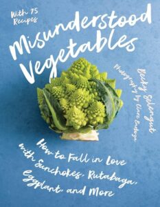 Book cover: A blue background with a head of Romanesco broccoli in the middle. The title "Misunderstood Vegetables: How to Fall in Love with Sunchokes, Rutabaga, Eggplant, and More" is written around the broccoli in white cursive.