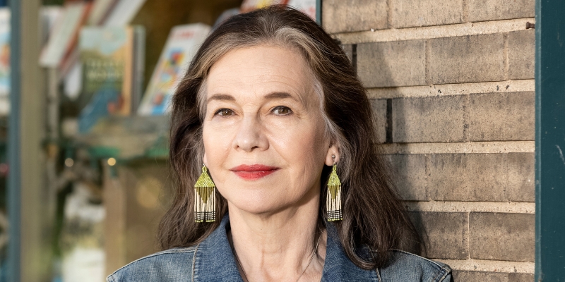 Headshot of Louise Erdrich (with fair skin and brunette/blonde hair, and beaded dangling earrings)