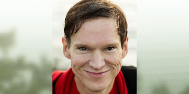 Headshot of Rob Sheffield (with fair skin, short brown hair, red t-shirt, and black hoodie)