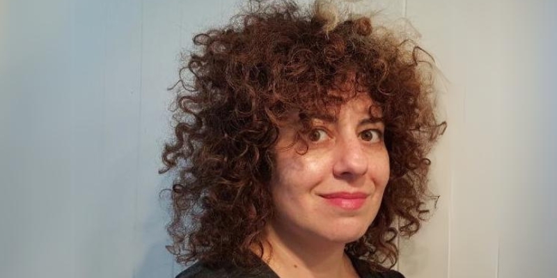 Headshot of Alison Fensterstock (with fair skin and shoulder-length curly brown hair)