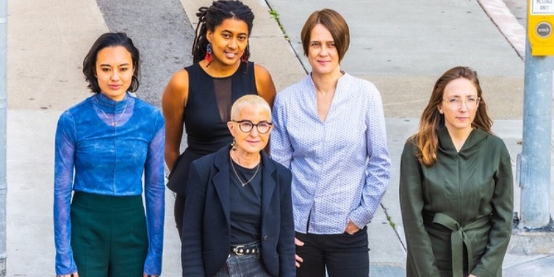 Group photo of the Myra Melford Fire and Water Quintet posing on an empty sidewalk.