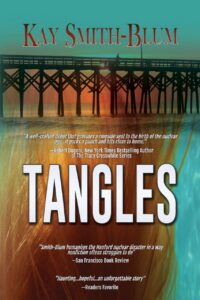 Book cover for Tangles by Kay Smith-Blum, featuring a sunset scene with a wooden pier stretching across the water, while the text highlights critical acclaim. The warm colors in the background blend with strands resembling hair.