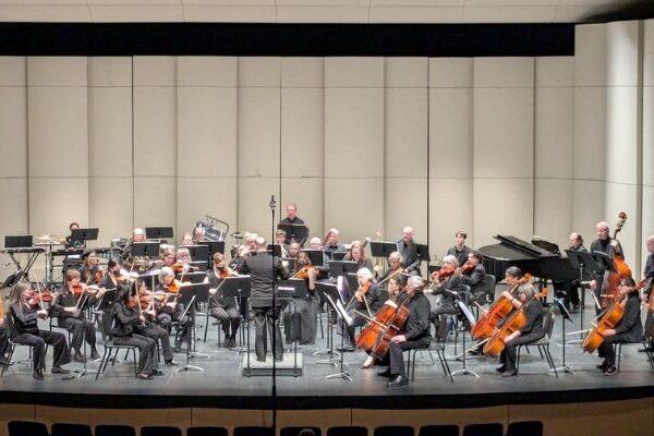 Philharmonia NW Orchestra on stage in a large auditorium