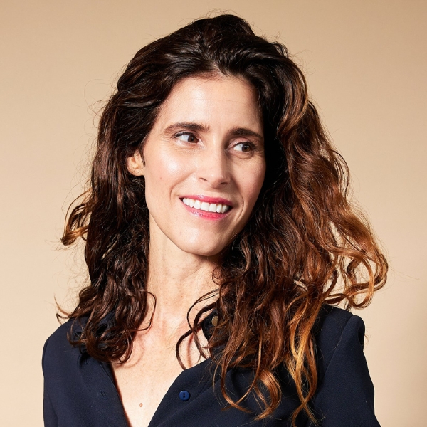 Headshot of April Pride (with fair skin, wavy brown hair, and navy button-up blouse)