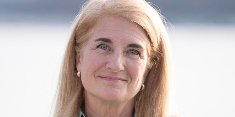 Headshot of Wendy Norman (with long blonde hair, fair skin, and small gold hoop earrings)