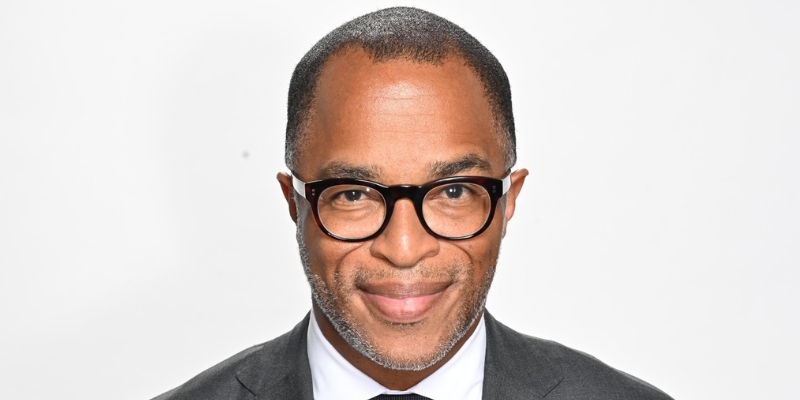 Headshot of Jonathan Capehart (with brown skin, eyeglasses, black/grey buzzcut, and suit)
