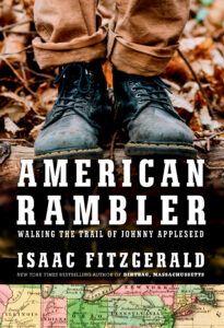 Book cover of "American Rambler: Walking the Trail of Johnny Appleseed" by Isaac Fitzgerald, featuring a pair of worn boots standing on a fallen log in a forest, with a map of the eastern United States at the bottom.
