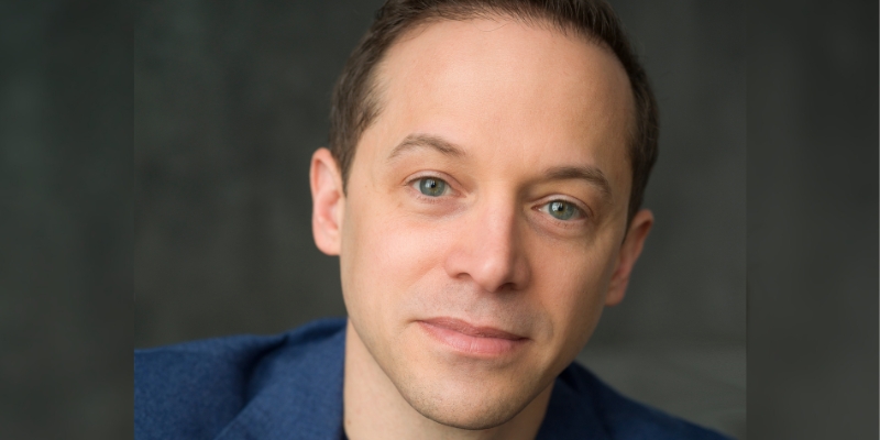 Headshot of David Epstein (with fair skin and short brown hair, wearing a blue suit jacket.)