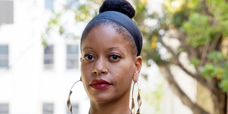 Headshot of Khiara M. Bridges (with brown skin and hair in a bun, wearing black headband and gold hoop earrings)