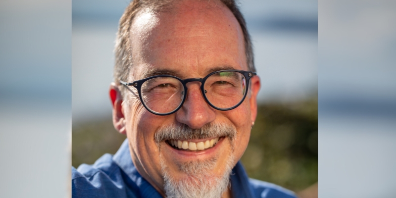 Headshot of Ron Krabill (with light skin, grey facial hair, and eyeglasses)